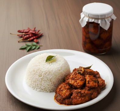 Traditional Spicy Fish Pickle served with rice in a white plate and the pickle jar