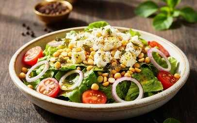 Traditional homestyle vegetarian salad prepared with fresh Panikoorka, chickpeas, lettuce, onions and tomato's and kept in a ceramic plate.