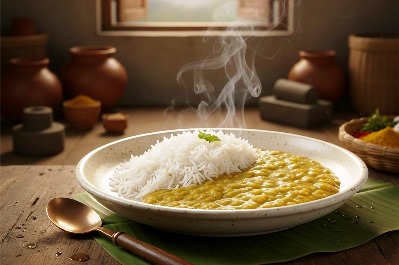 Warm Food for Digestion- rice and curry served in a plate and kept on a banana leaf with traditional kitchen background with mud pots, grinding and pounding stones
